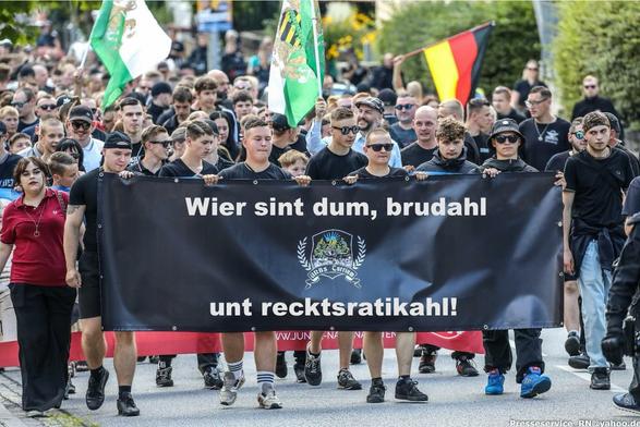 Foto eines Aufmarschs rechtsradikaler Jugendlicher. Das Motto ihres Frontbanners wurde zu „Wier sint dum, brudahl unt recktsratikahl!“ abgeändert.