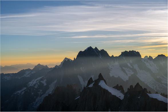 Orange and blue skies above the snow covered jagged peaks of the Chamonix Aiguilles.