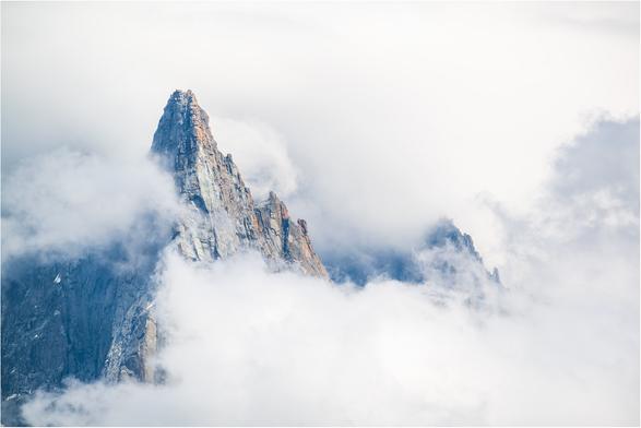 The conical shape of the mountain appearing through the clouds in Chamonix.