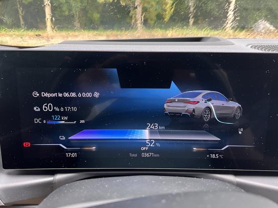 Digital dashboard of BMW i4 electric vehicle showing charging information, battery percentage, range, and charging power. The display reads 60% charge target, 243 km range, and 122 kW charging power.
