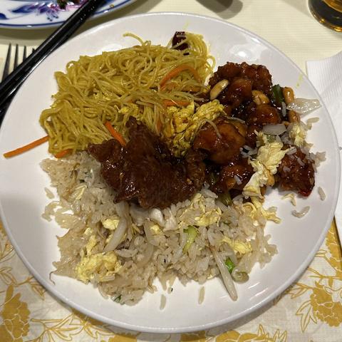 A plate of meat, rice, and noodles