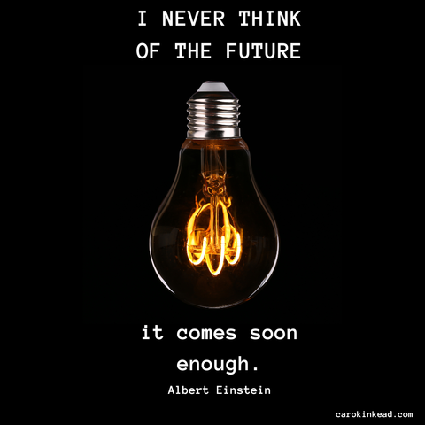 On a black background is a light bulb, the energized filament visible through the clear glass. Around it are the words, "I never think of the future. It comes soon enough." Albert Einstein