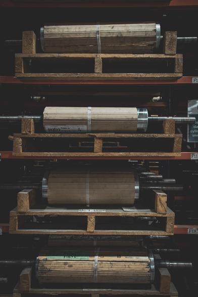 Printing rolls wrapped in cardboard stored on pallets.
