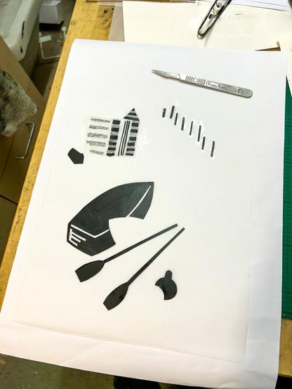 A hand made stencil for a screenprint, made from polyester sheet cut out in various shapes and painted black.
