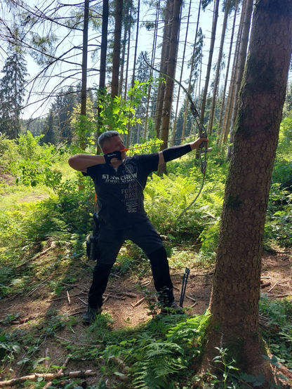 Bogenschütze im seitlichen Profil. Im Wald und leicht bergauf schieße ich hier auf ein 3D-Ziel