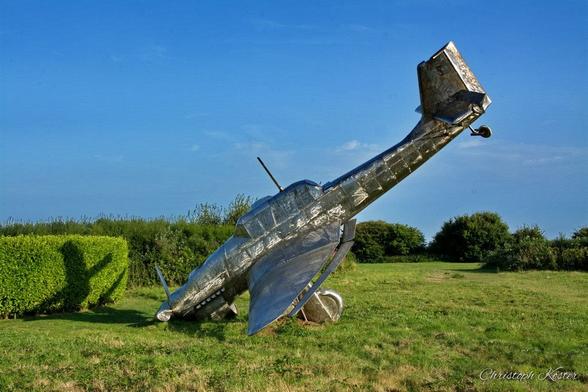 monochrome picture of the stainless steel scuplture of a german STUKA crashing to the ground at the Battle of Britain Memorial in Capel-Le-Ferne