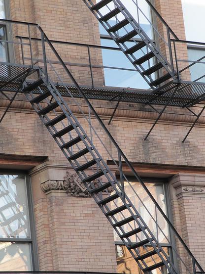 A brick building with a metal fire escape staircase.