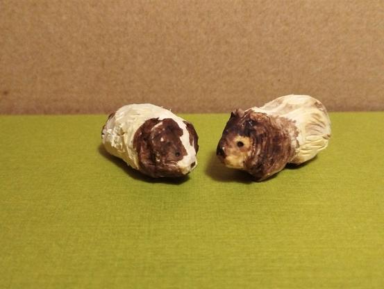 Deux cochons d'inde en bois. La texture donne un peu l'impression que les poils sont longs