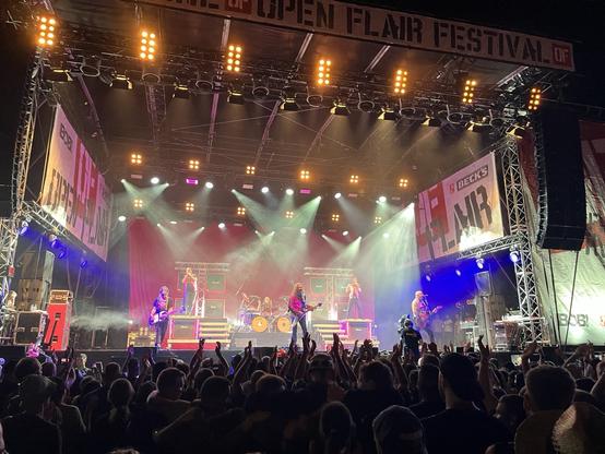 Eine hell erleuchtete Bühne bei Nacht. Die Band JBO spielt beim Open Flair Festival.