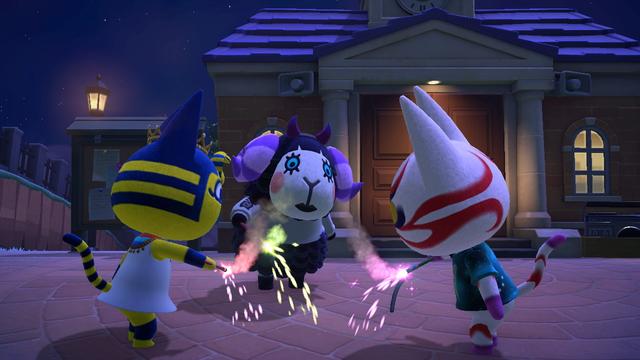 Animal Crossing: New Horizons screenshot. Set in the town square at night in front of the Resident Services building. Muffy (black sheep, white face, blue eyes), Kabuki (white cat with yellow eyes and red striping similar to a traditional Kabuki mask), and Ankha (yellow cat with blue stripes on her tail, blue ears, and a yellow / blue snake coming out of her forehead similar to a Pharaoh's headdress) are all leaning toward each other with brightly lit sparklers in their hands.
