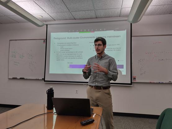 Aal man standing in front of a screen presenting slides