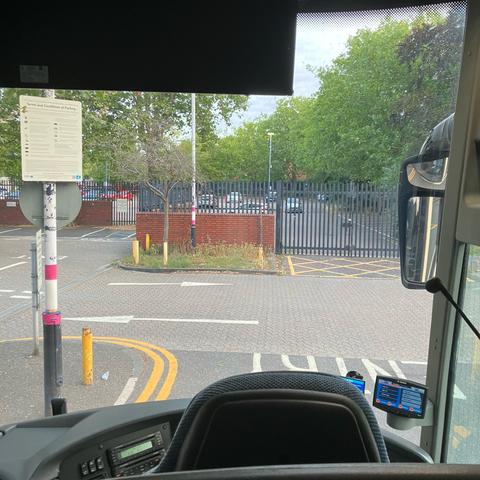 A photo of a car park taken from immediately behind the driver’s seat of a coach being used as a rail replacement bus