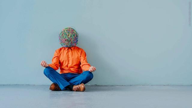 Neuer Trend Rawdogging: Ein Mann mit einem Korbgeflecht um den Kopf sitzt vor einer Wand und meditiert. (Foto: IMAGO, IMAGO / Westend61)