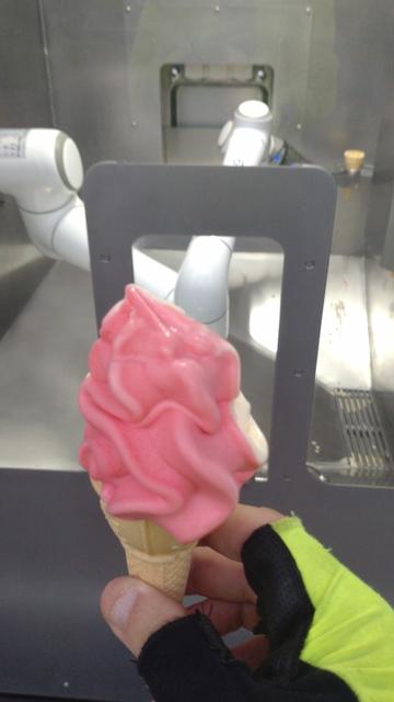 Eine bereits siffende Portion Softeis Erdbeer-Vanille in meiner Hand.