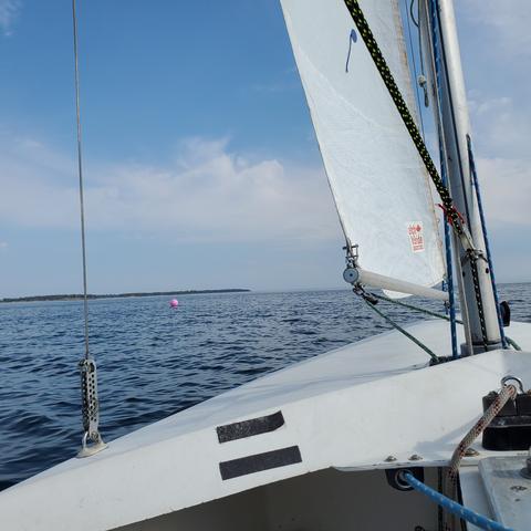 Pink floating ball, upwind, sailing course marker in middle of ocean. View from my pilot/captain seat in sailboat.