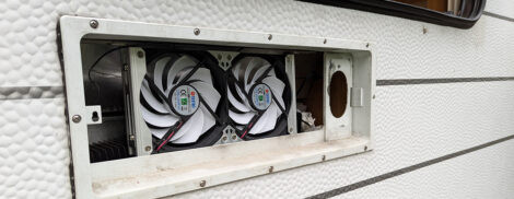 Ein 120cm Doppellüfter ist vor den Kühlrippen eines Wohnwagenkühlschranks in der Revisionsöffnung montiert.