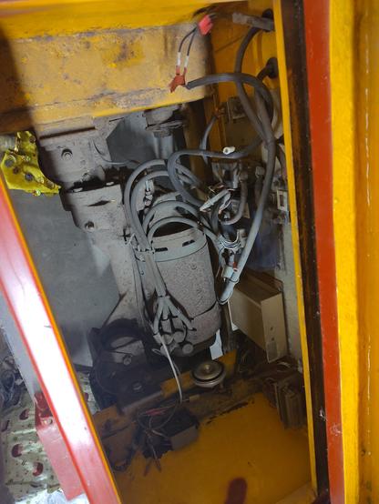 a dusty rusty great big electric motor in a compartment of the tug