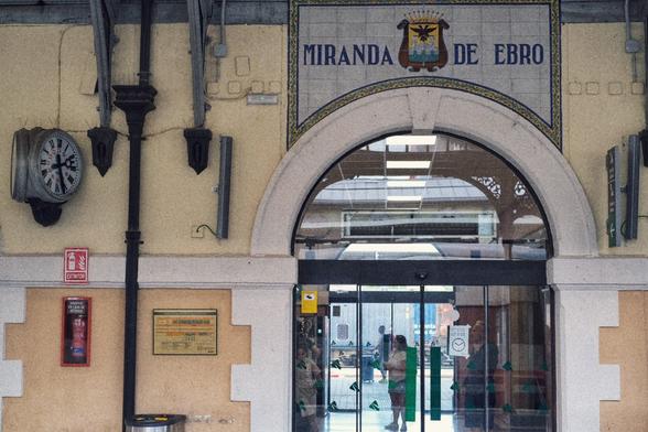 Entrance to the station building  with a clock on the left side and the writing "Miranda de Ebro" over the arch of the entrance.