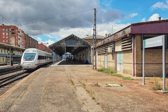 Entrance to the station building  with a clock on the left side and the writing "Miranda de Ebro" over the arch of the entrance.