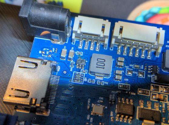 Closeup of a circuit board, with an emphasis on a small damaged IC. The damage is fatal but hard to see, as the chip is only about 1mm wide and about 2mm long.