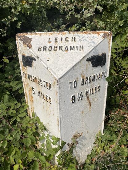 Cast iron mile post with black lettering and black manicules. Pointing to #Worcester and #Bromyard.
