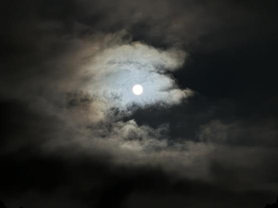 Tonight’s full moon shining through the clouds. (Zoomed in)