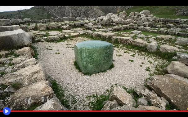 Imponente cubo di pietra verde campeggia in mezzo alle rovine di un antico tempio.
