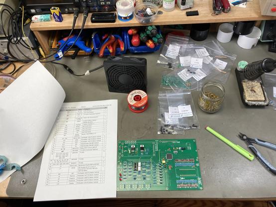 A half-built Retro Chip Tester Pro PCB on my workbench, components and tools scattered around it.