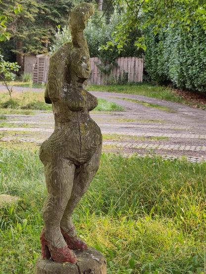 Skulptur eines Akts mit roten Schuhen.