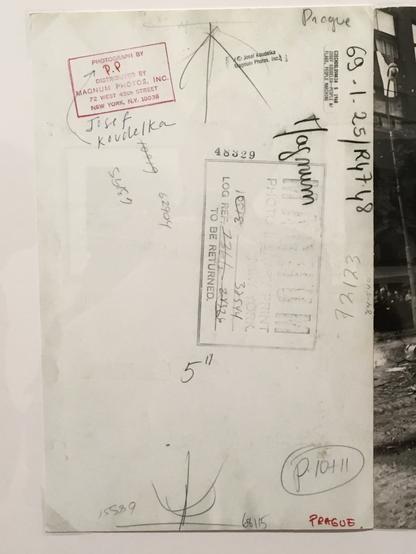 rear of aforementioned photo, stamped with many marks and with handwritten annotations including the site of the event, the date of publication, and so forth