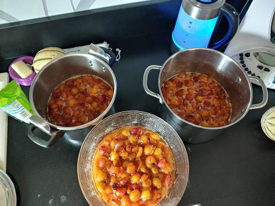 3 récipients remplis de mirabelles dénoyautées et baignant dans le sucre