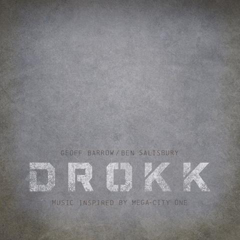 The cover art for the album 'Drokk (Music Inspired By Mega-City One)'.

The artwork is mostly just a mottled grey concrete-like texture with 'DROKK' towards the bottom in a white, blocky stencil font, with a worn, rough texture. 'GEOFF BARROW / BEN SALISBURY' is above the title in dark grey, and 'MUSIC INSPIRED BY MEGA-CITY ONE' below, also in dark grey. 

And that's it.