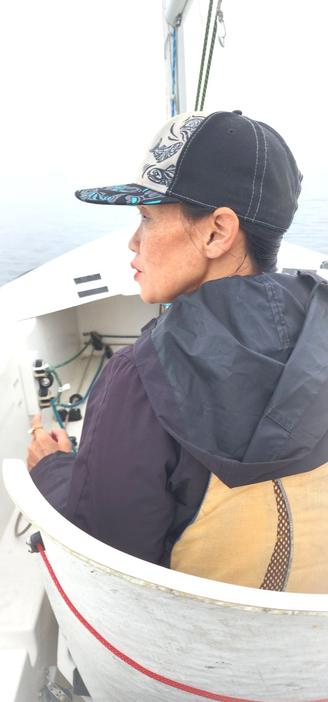 Me in pilot/captain seat in Martin 16, 2 seater sailboat. Taken by my Mom who was sitting in stern seat behind me. Left side profile portrait. Background is fogged out ocean & skies.