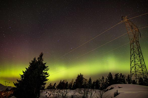 photo - aurora from geomagnetic storm / space weather over high tension electric power line