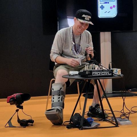 Me sitting on stage with Game Boy and Virtual Boy, making music.
