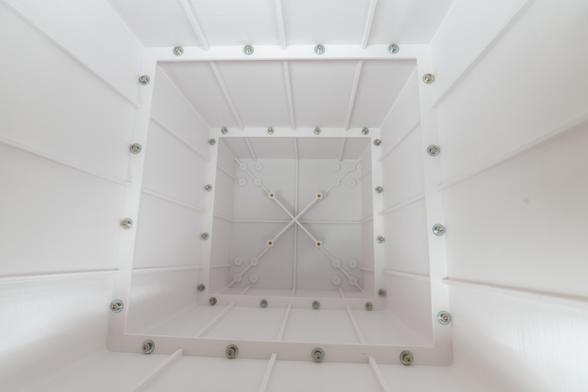 Photo down into the shell of a large 3D-printed planter. Two rows of screw heads are visible that hold the individual parts together.