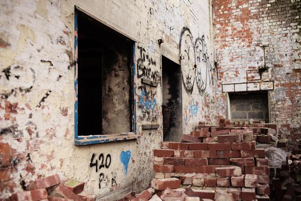 This is a building at the docks of Kingston upon Hull in England. Used to be the HQ of a large Ocean Liner Company.
Left derelict since many years. 
Dangerous playground for local  kids.
Lots of things to smash up. Broken windows. Lots of red bricks etc. etc. 
But....... still fascinating in a strange way.