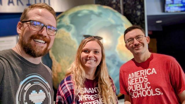 Nick, Cassie, and Chris pose for a selfie in front of a globe at the Grand Rapids Public Museum