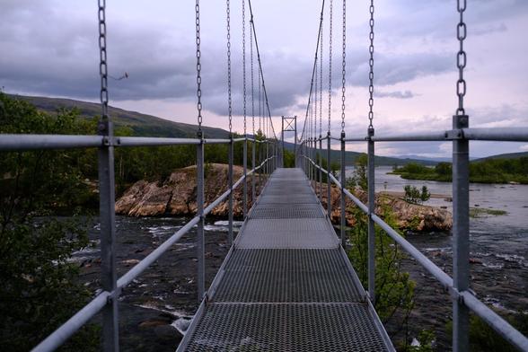 Metallische Hängebrücke über den Fluss.