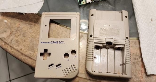 A Nintendo game boy shell sitting on a table. It looks well loved, but clean