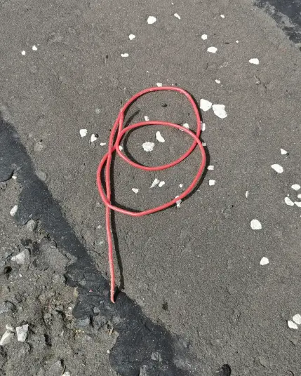 Litter. Red plastic cord in the shape of a magickal sigil.