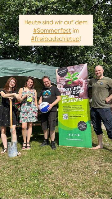 Bild von uns ehrenamtlichen Mitgliedern von #GemeinsamBuddeln vor dem Stand im Freibad Schlutup, im Hintergrund steht eine große Eiche und darauf ein Schriftzug: "Heute sind wir auf dem Sommerfest im #FreibadSchlutup".