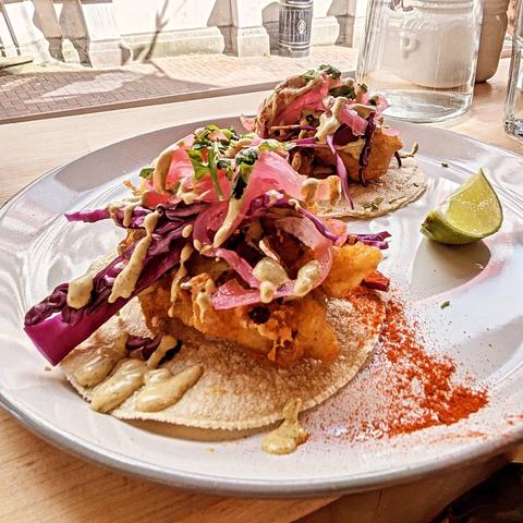 Two fish tacos on a plate.