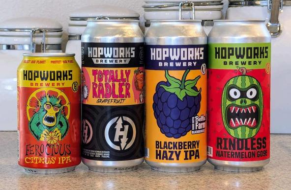 Four cans of fruited beer from Hopworks Brewery of Portland, Oregon: Ferocious Citrus IPA, Totally Radler, Blackberry Hazy IPA, and Rindless Watermelon Gose.