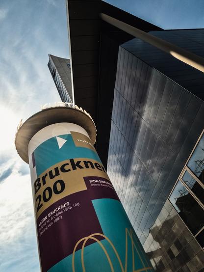Litfaßsäule vor dem schwarzen Würfel in Leipzig, Konzertplakat für das Brucknerkonzert