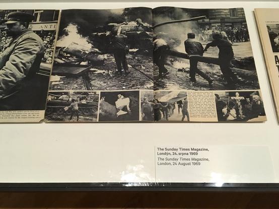 spread from the magazine:

top: protesters advance on tank in smokefilled cobblestone street with fire burning

bottom : smaller scenes, several of which feature protesters with the national flag