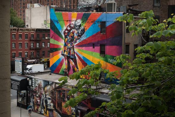 Photo of a very colorful mural depicting the famous photo of an American sailor hugging and kissing a woman