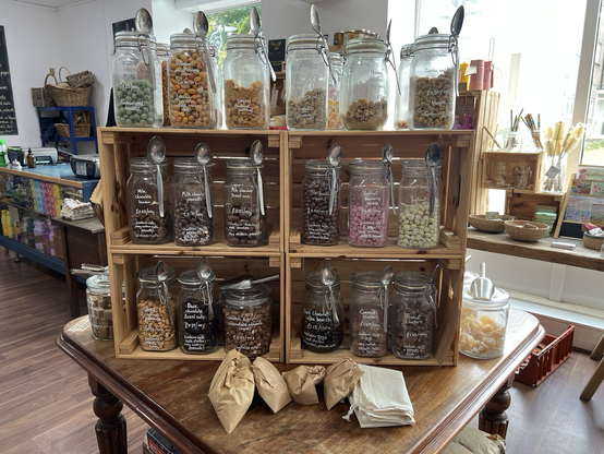A shelf in the shop with large jars of all sorts of nuts and chocolate treats