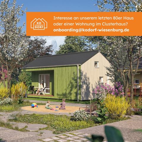 Ein Bild eines der Kleinhäuser bei sonnigem Wetter. Davor ein Sandkiste mit 2 Kindern. Darüber der Text: "Interesse an unserem letzten 80er Haus oder einer Wohnung im Clusterhaus? onboarding@kodorf-wiesenburg.de"