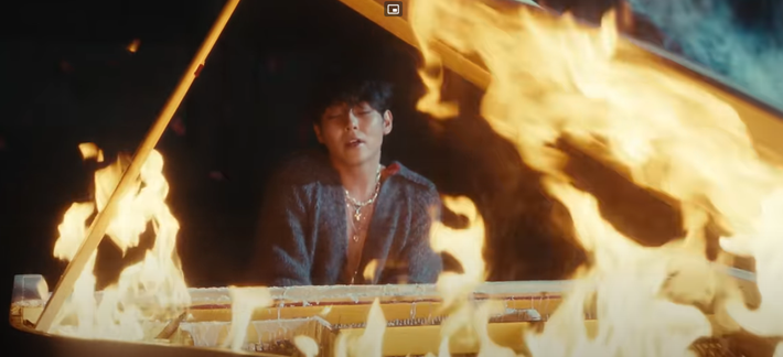 Woosung playing a flaming piano in the 'Day That I Died' MV